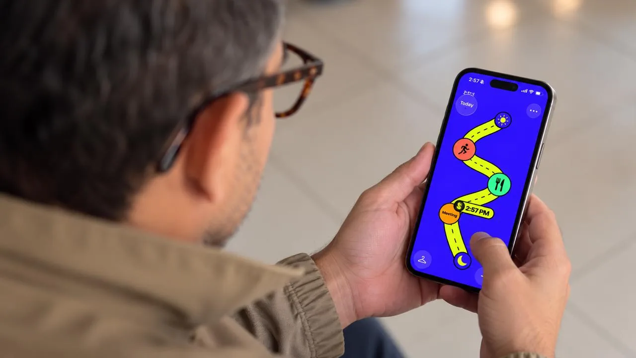 Terry holding a phone that shows the Serpentime app.